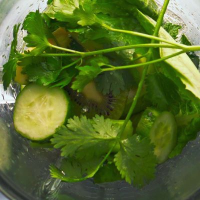 Home top view blender start mixing vegetables herbs in super slow mot